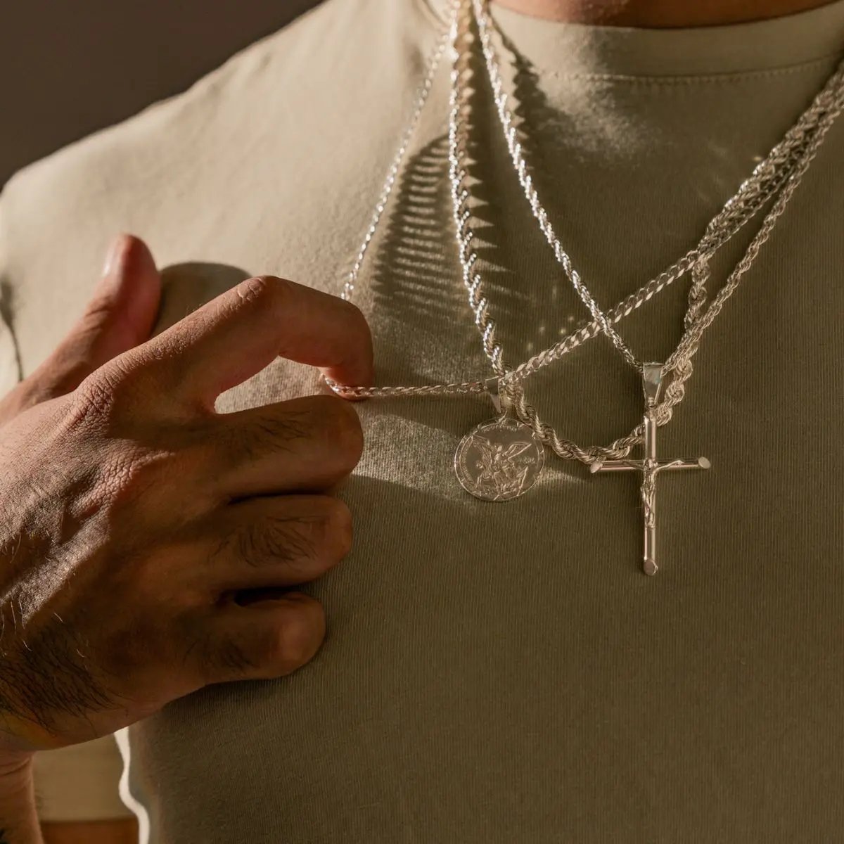 Modelo masculino hombre luciendo layering cadenas de plata .925. Diseño versátil que realza look casual