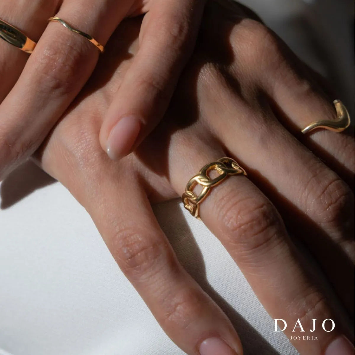 Modelo mujer usando combinación set de joyería anillos Oro Vermeil plata .925 con baño de oro de 14K quilates estilo elegante mano en rodilla