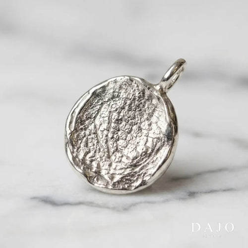 Dije Huella de plata .925 con la huella grabada en relieve, sobre mármol