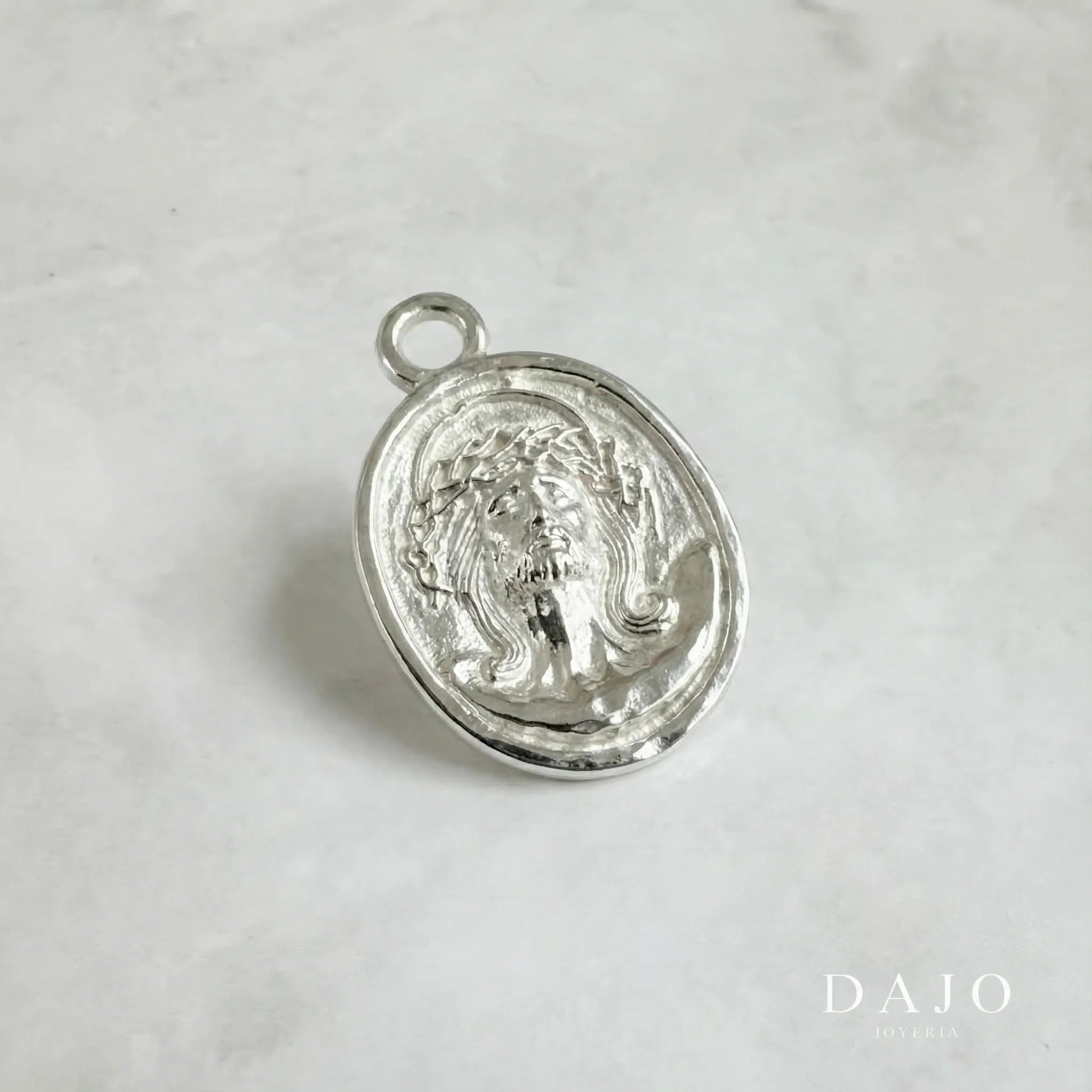 Este dije de plata .925 muestra el rostro de Jesucristo con la corona de espinas y la mirada elevada al cielo, con los ojos cerrados en una expresión de entrega y conexión divina.
Su imagen representa sacrificio, fe y esperanza... al mismo tiempo amor incondicional y fortaleza.