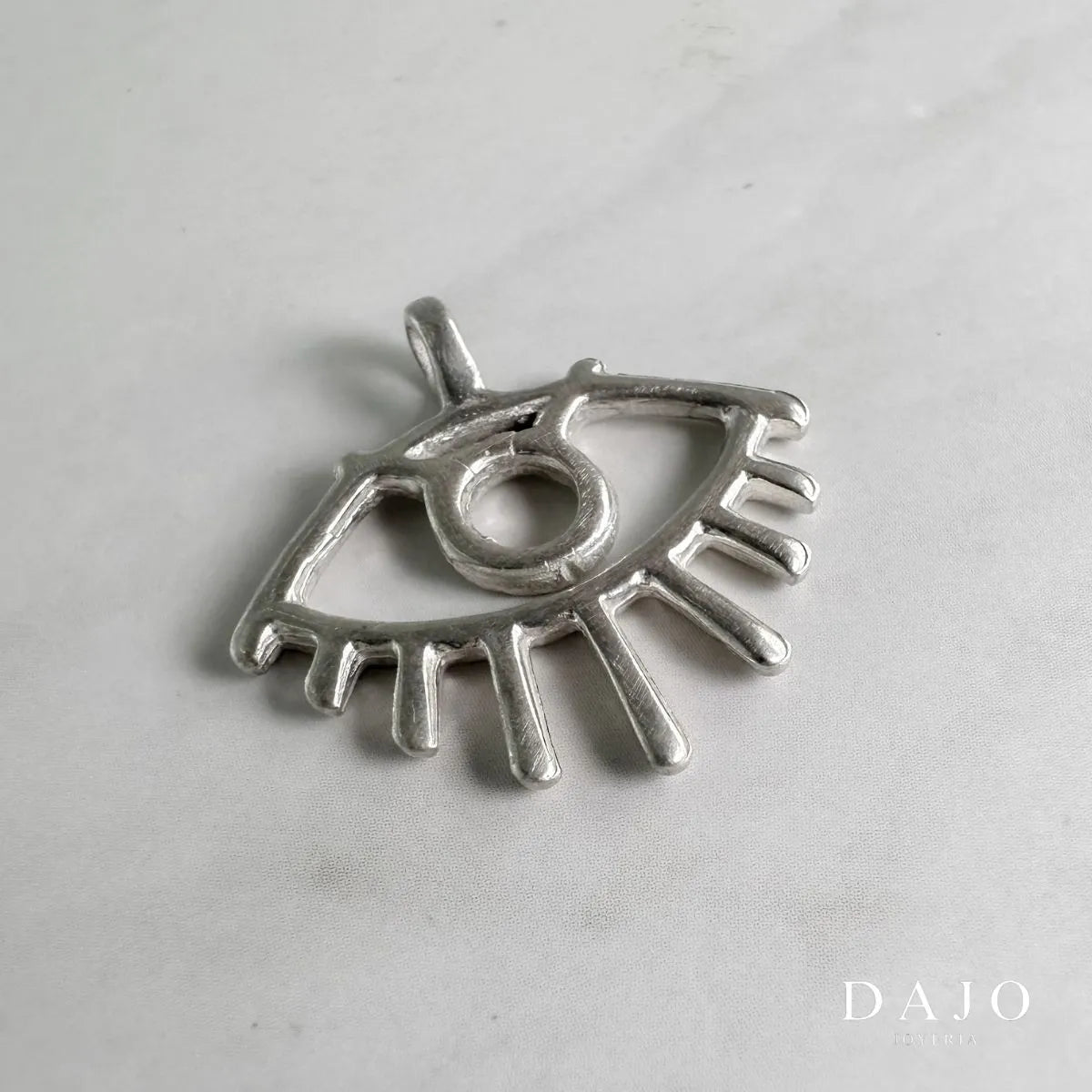 Este dije de plata .925 presenta un diseño en forma de ojo, conocido en diversas culturas como "ojo turco" o "nazar".
Tradicionalmente, se considera un amuleto protector contra energías negativas y el mal de ojo. Añade un toque elegante a tu estilo, un símbolo de protección y buena fortuna