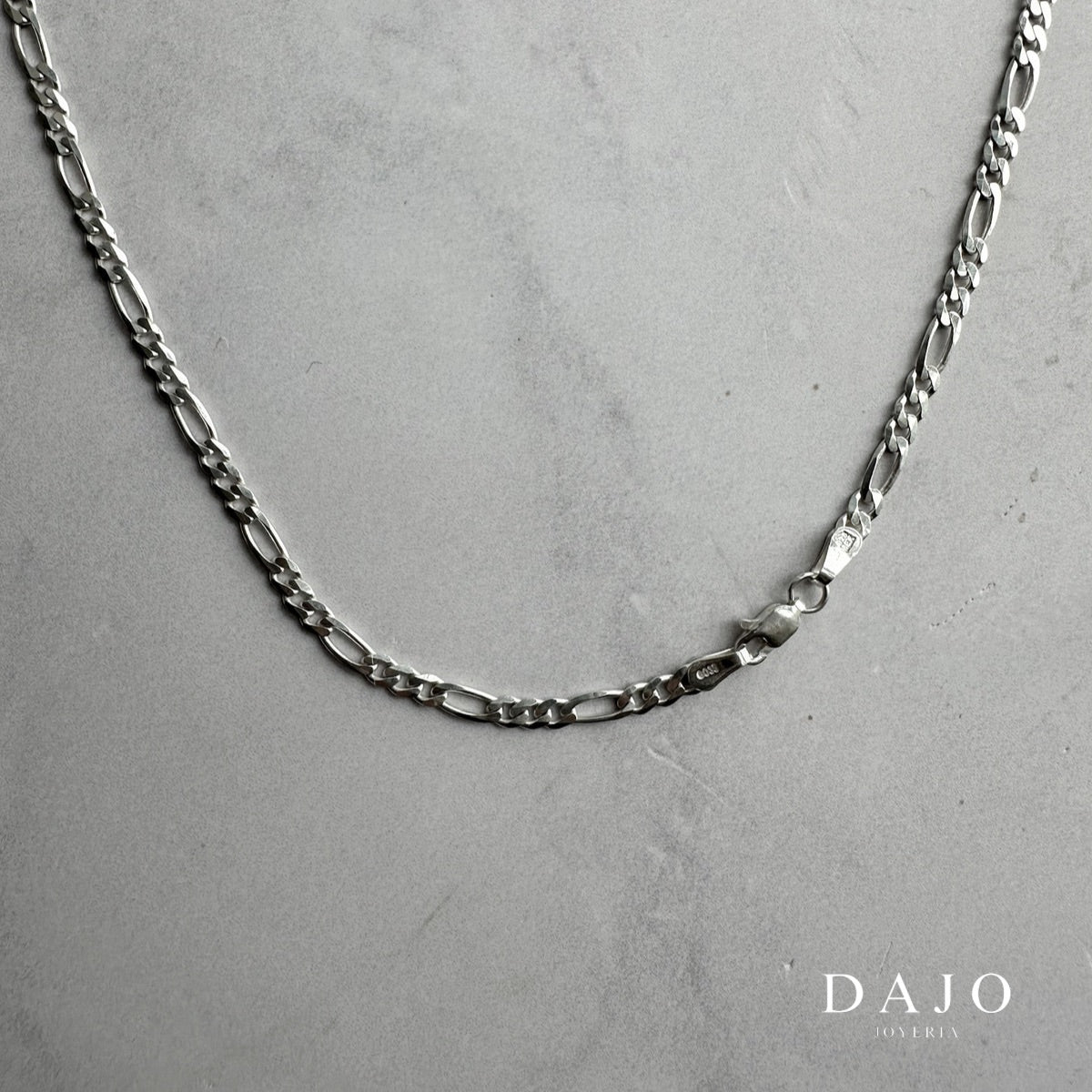 Esta cadena de plata .925 tiene el clásico patrón Figaro: tres eslabones cortos y uno largo.
Con 4 mm de ancho, tiene una presencia llamativa pero elegante, ideal si buscas algo con carácter.
Un diseño atemporal que combina bien con todo y nunca pasa de moda