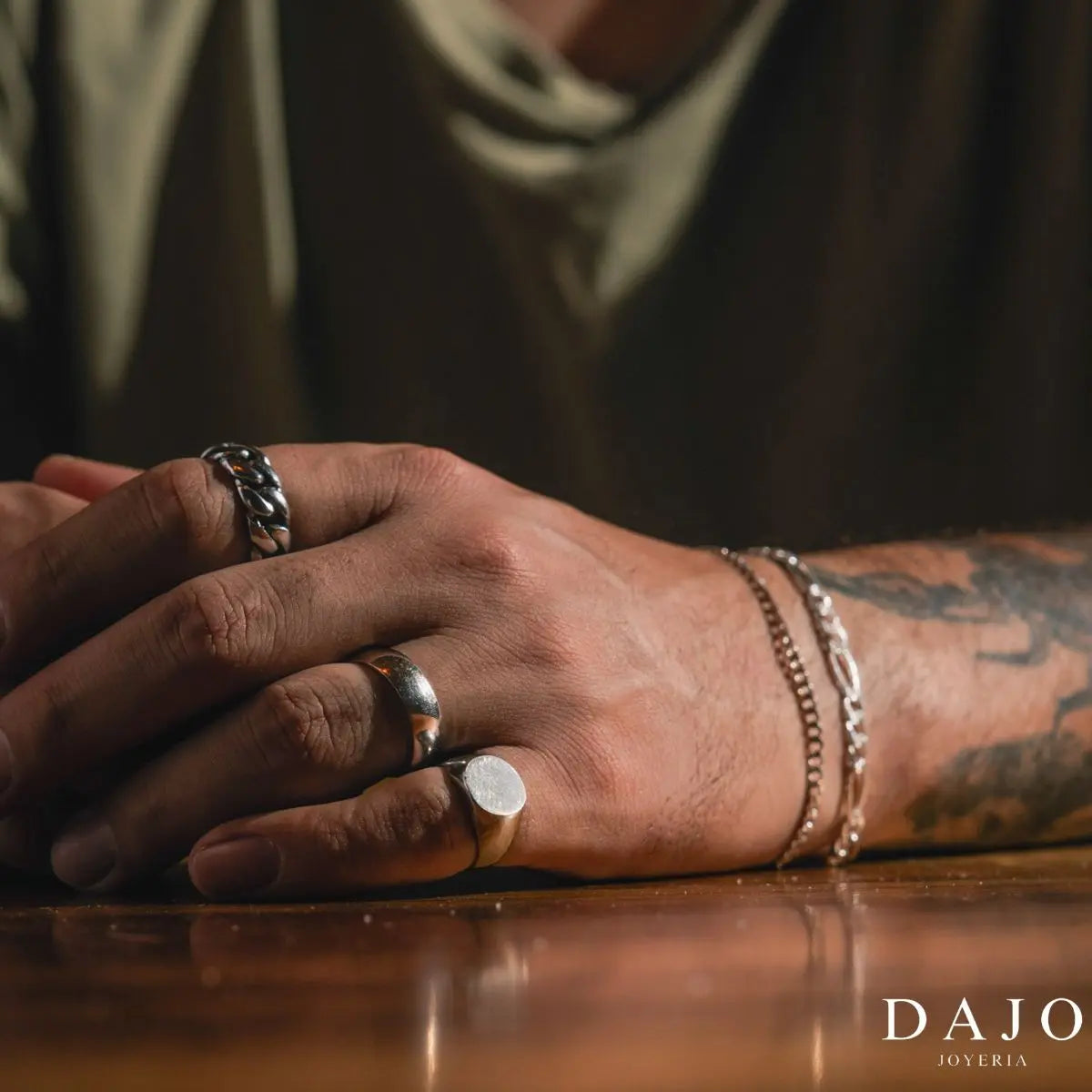 Modelo hombre en mesa de madera luce set combinación de anillos de plata .925, destacando la simplicidad y la elegancia de su diseño