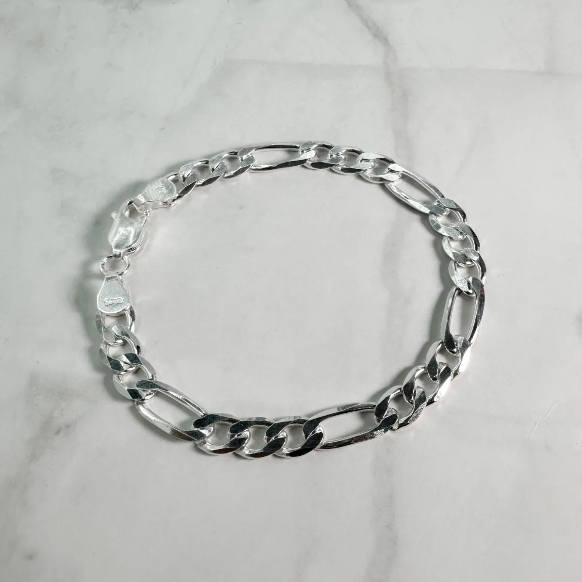 Esta pulsera de plata .925 está compuesta por eslabones tipo Cartier o Fígaro, con el clásico patrón de tres eslabones cortos seguidos de uno largo.
Con 6 mm de ancho, es una pieza robusta que destaca por su elegancia tradicional con un toque de fuerza visual.
Ideal si buscas una joya con presencia que proyecte estilo clásico, seguridad y carácter sin esfuerzo