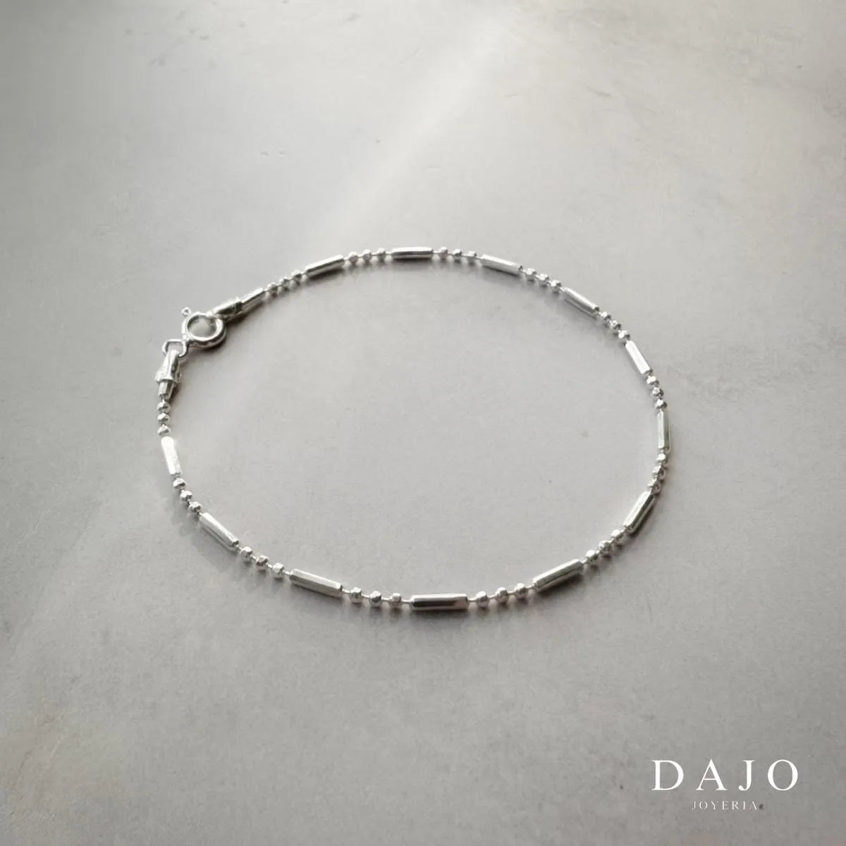 Esta pulsera de plata .925 presenta un diseño distintivo y poco común, compuesto por eslabones que alternan un pequeño perno seguido de tres esferas, creando un patrón único y elegante.
Con un ancho de 1 mm, esta cadena delgada aporta sofisticación y sutileza, proyecta tu tu aprecio por los diseños exclusivos y la atención al detalle, ideal para quienes buscan una pieza llamativa sin ser ostentosa.