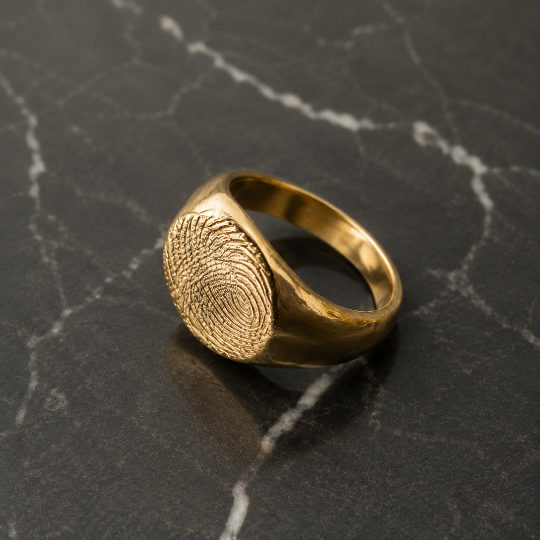 Anillo sello redondo con huella en oro solido sobre marmol negro - DAJO Joyeria