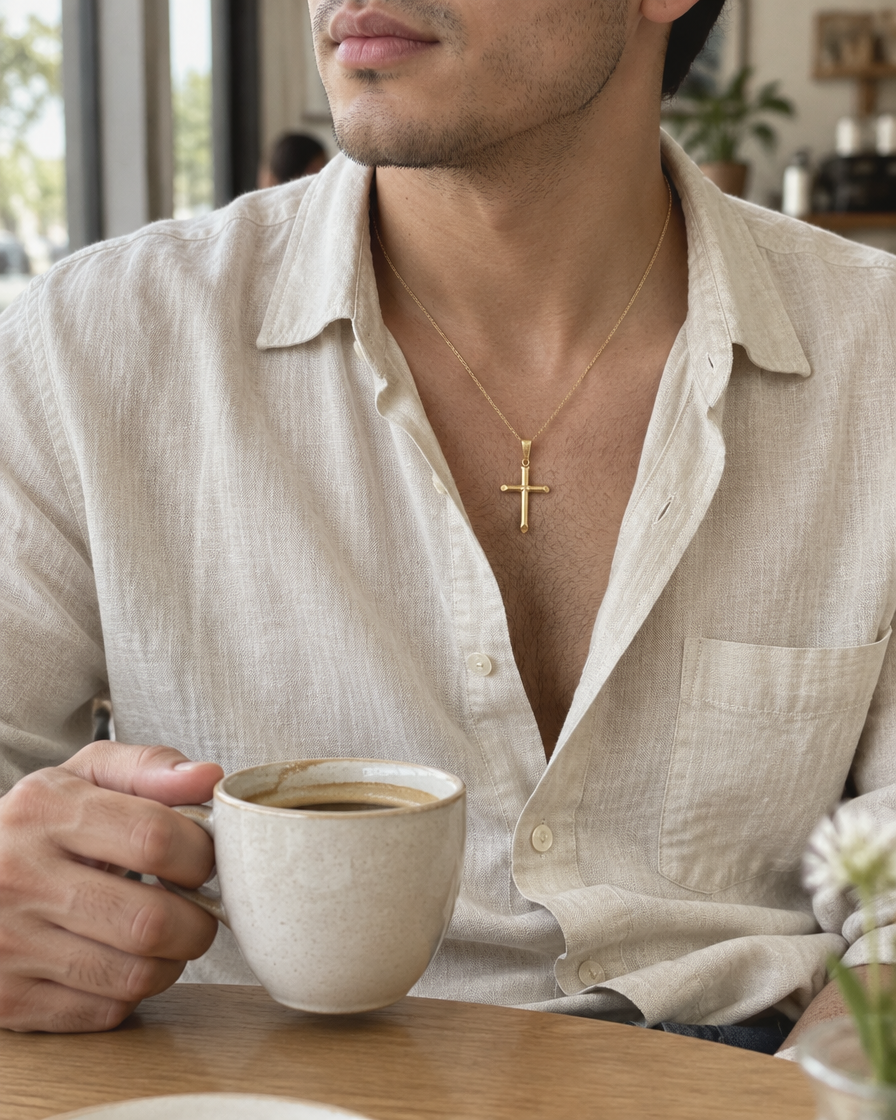 Hombre con el Dije Cruz tubular de oro sólido de DAJO tomando café