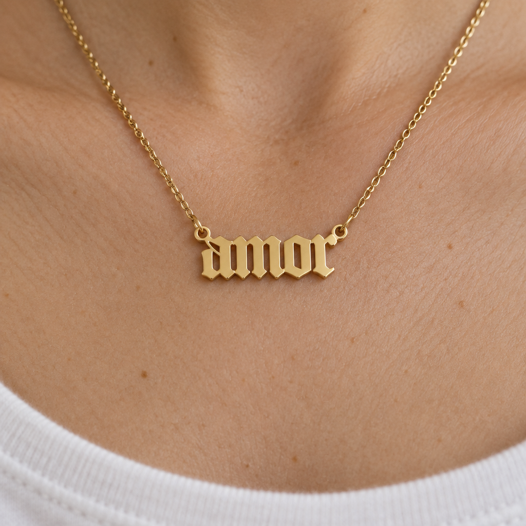 Dije Amor de oro sólido de DAJO puesto, letra gótica con una argolla en cada punta