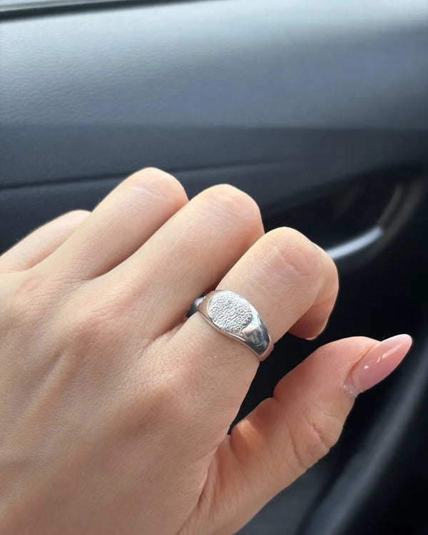 Mano con el anillo Sello Redondo de plata: la huella se ve nítida