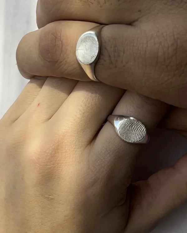 Dos manos con sus anillos de huella, uno de cada uno