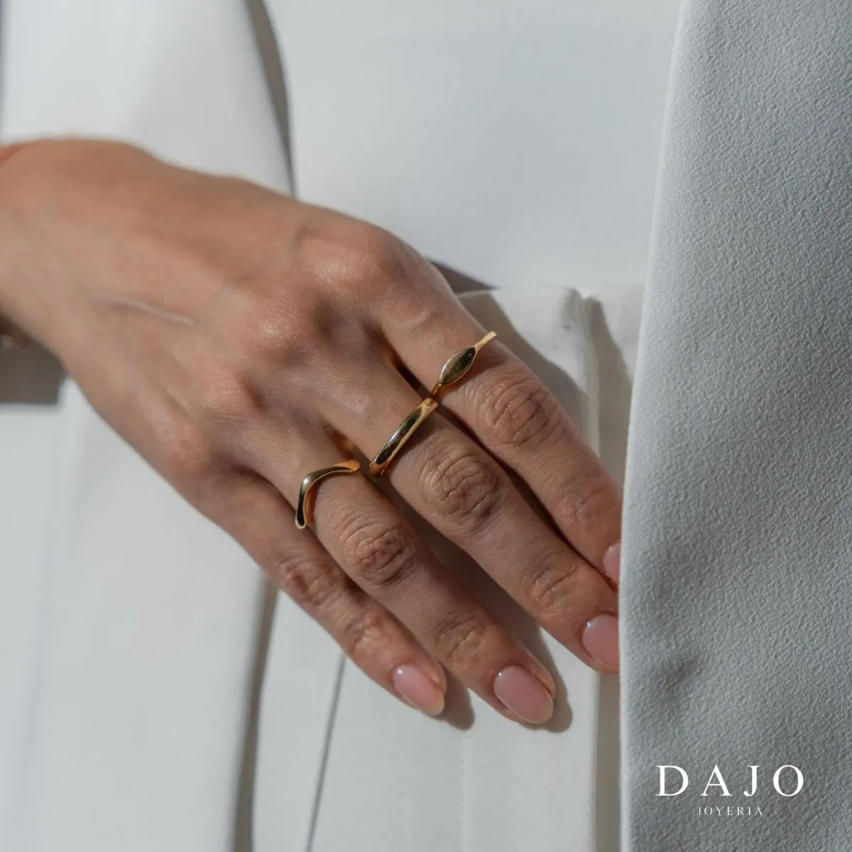 Modelo mujer usando combinación set de joyería anillos y cadenas Oro Vermeil plata .925 con baño de oro de 14K quilates estilo elegante con saco blazer traje. Anillo balance, argolla, botanica