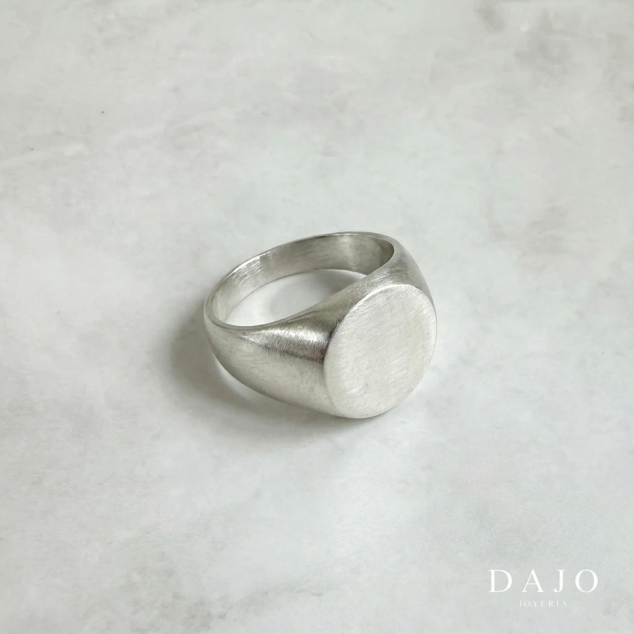 Anillo minimalista con sello redondo de plata .925, destacando la simplicidad y la elegancia de su diseño
