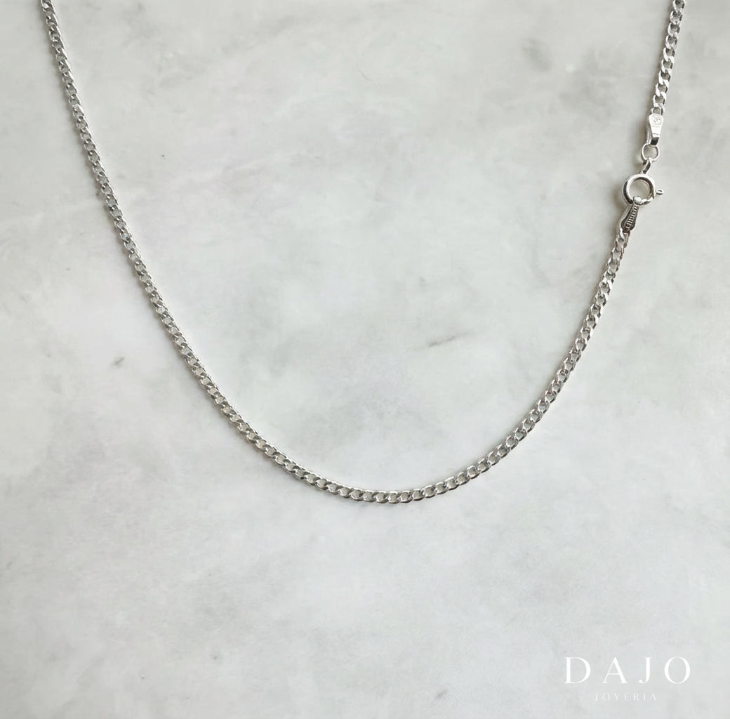 Con eslabones tipo barbado y un grosor de 2 mm, esta cadena de plata .925 combina la fuerza del diseño clásico con una presencia sutil pero firme.
Ideal para quienes buscan equilibrio entre elegancia y carácter, su estilo sobrio refleja la esencia del lujo atemporal.
Perfecta para lucir sola o como base de layering con intención.