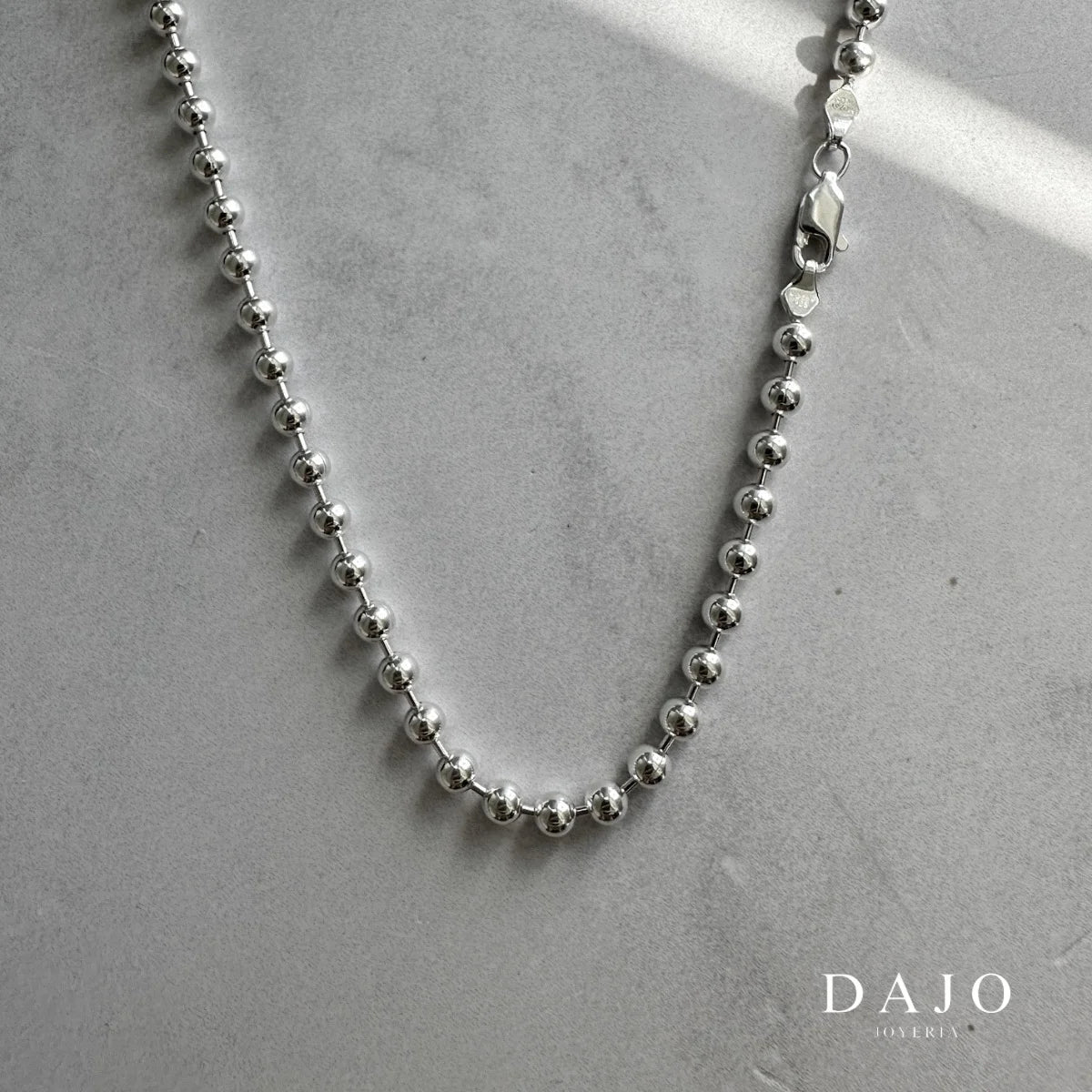 Esta cadena de plata .925 está hecha con esferas de 3 mm unidas entre sí, lo que le da un look único, parecido a pequeñas perlas metálicas.
Tiene una presencia llamativa pero sin exagerar, ideal si buscas algo elegante con un toque diferente.&nbsp;Su diseño poco común la hace perfecta para destacar sin perder ese estilo minimalista y moderno