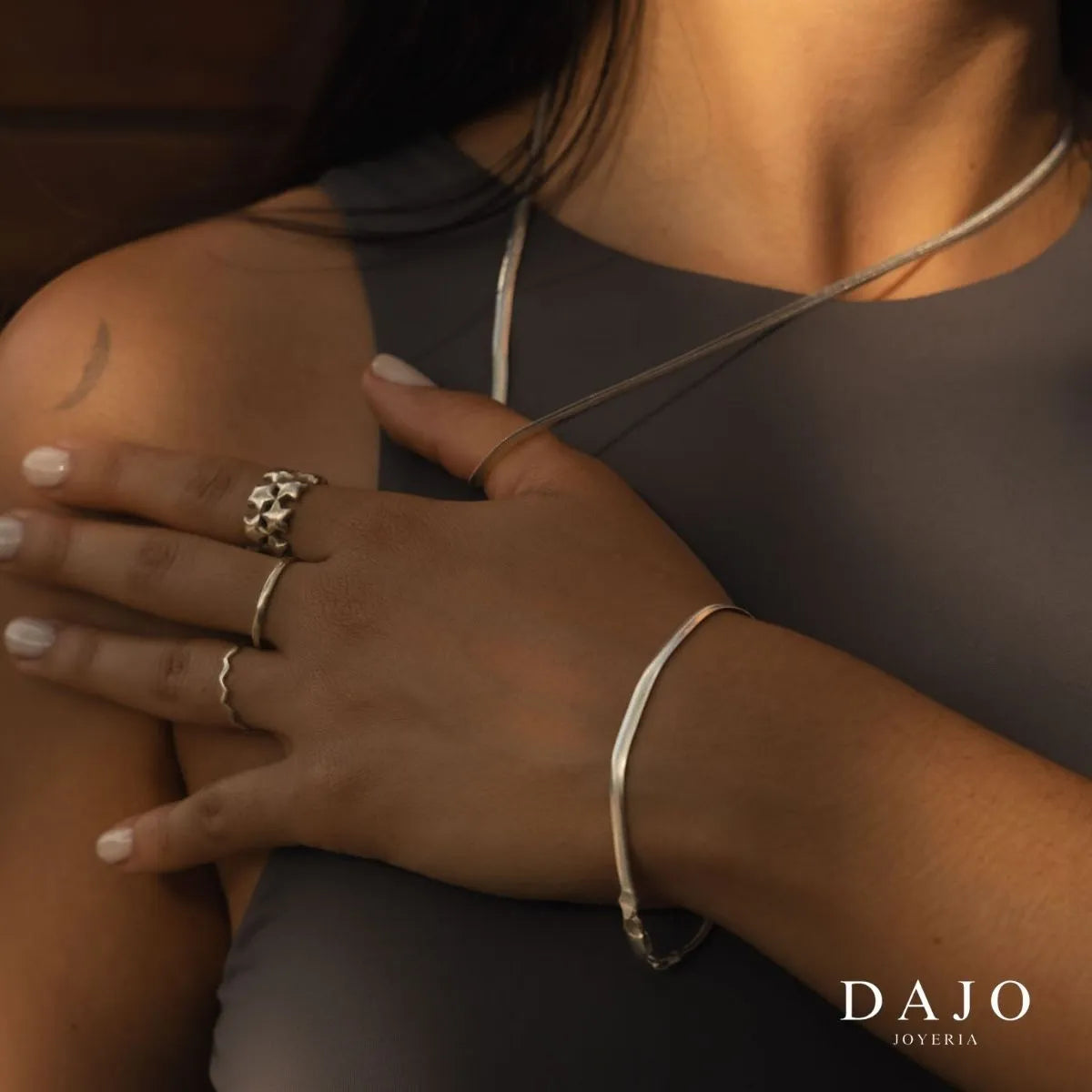 Modelo mujer usando combinación set de joyería anillos y cadena plata .925 estilo elegante. Anillo estrellas argolla cadena serpiente