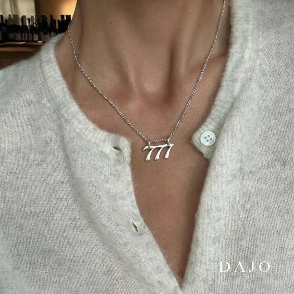 Dije Número Ángel 777 de plata .925 puesto con suéter gris | DAJO