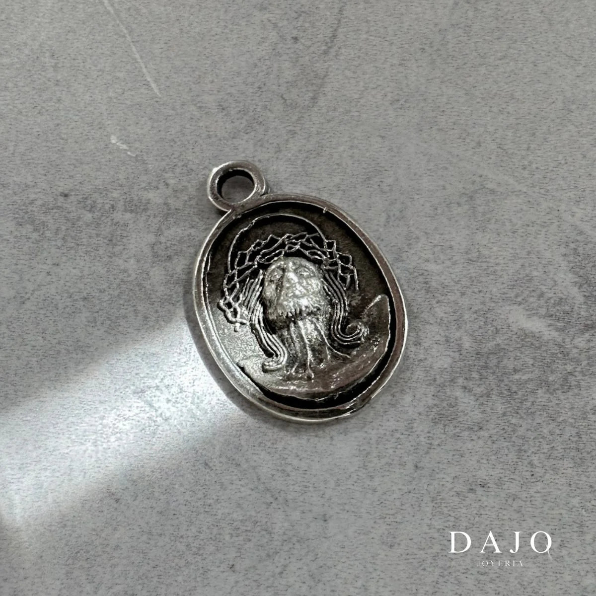 Este dije de plata .925 muestra el rostro de Jesucristo con la corona de espinas y la mirada elevada al cielo, con los ojos cerrados en una expresión de entrega y conexión divina.
Su imagen representa sacrificio, fe y esperanza... al mismo tiempo amor incondicional y fortaleza.
