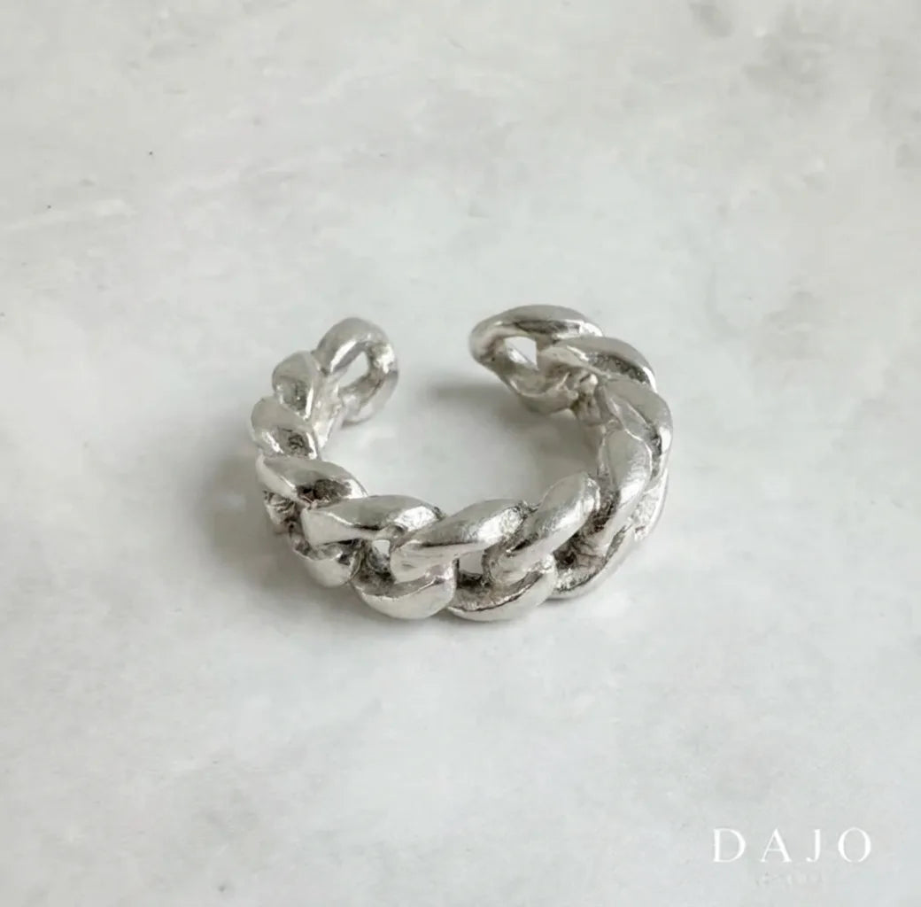 Este earcuff de plata .925 se ajusta cómodamente a tu oreja sin necesidad de perforaciones, permitiéndote experimentar con tu estilo de forma versátil.
Su diseño en forma de pequeña cadena en "U", hecho de eslabones entrelazados, aporta un toque moderno y atrevido.. Los eslabones representan conexión y fuerza, proyectando una imagen audaz y contemporánea con mucha personalidad.