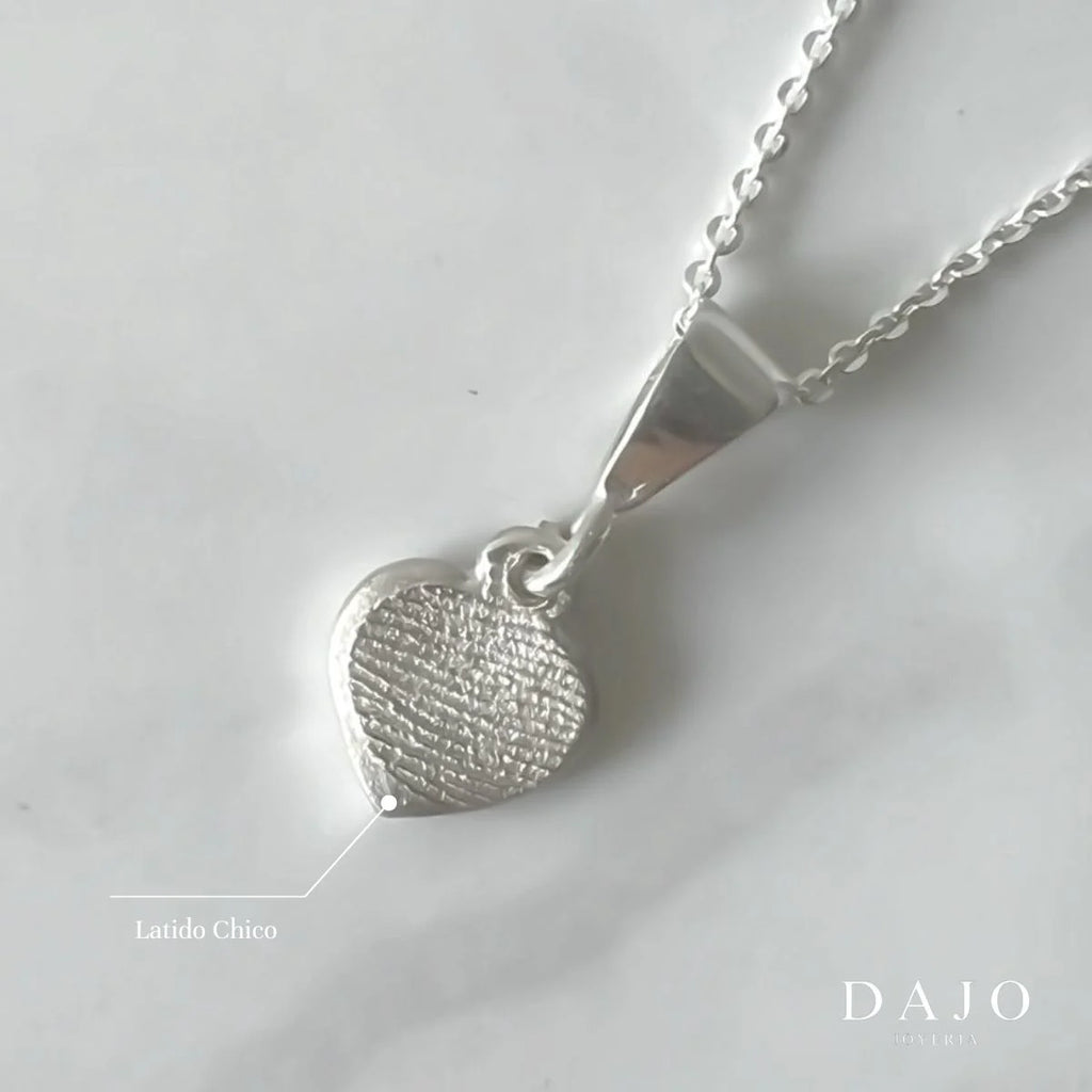 Dije Huella Latido chico de plata .925 con cadena, sobre mármol