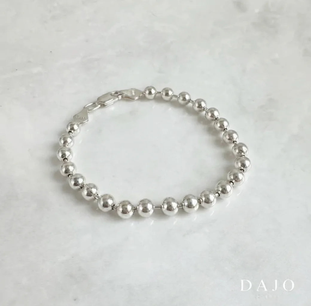 Esta pulsera de plata .925 se compone de esferas de 5 mm, creando un diseño sólido, vistoso y con mucha presencia.
Su volumen marcado la convierte en una pieza protagonista, perfecta para quienes disfrutan de joyería con carácter y estilo propio