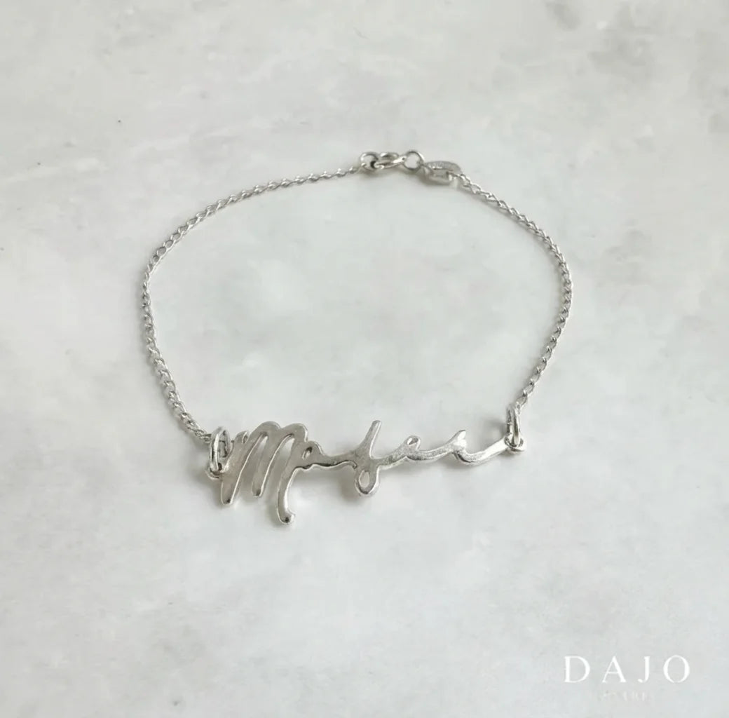 Esta pulsera de plata .925 tiene eslabones de 1 mm de grosor y una placa central que puedes personalizar con tu nombre, palabra, fecha o frase especial.
Contamos con 31 tipografías distintas para que elijas la que mejor exprese tu estilo.
Es una pieza única que refleja tu identidad y convierte tu joya en un mensaje significativo que llevas contigo