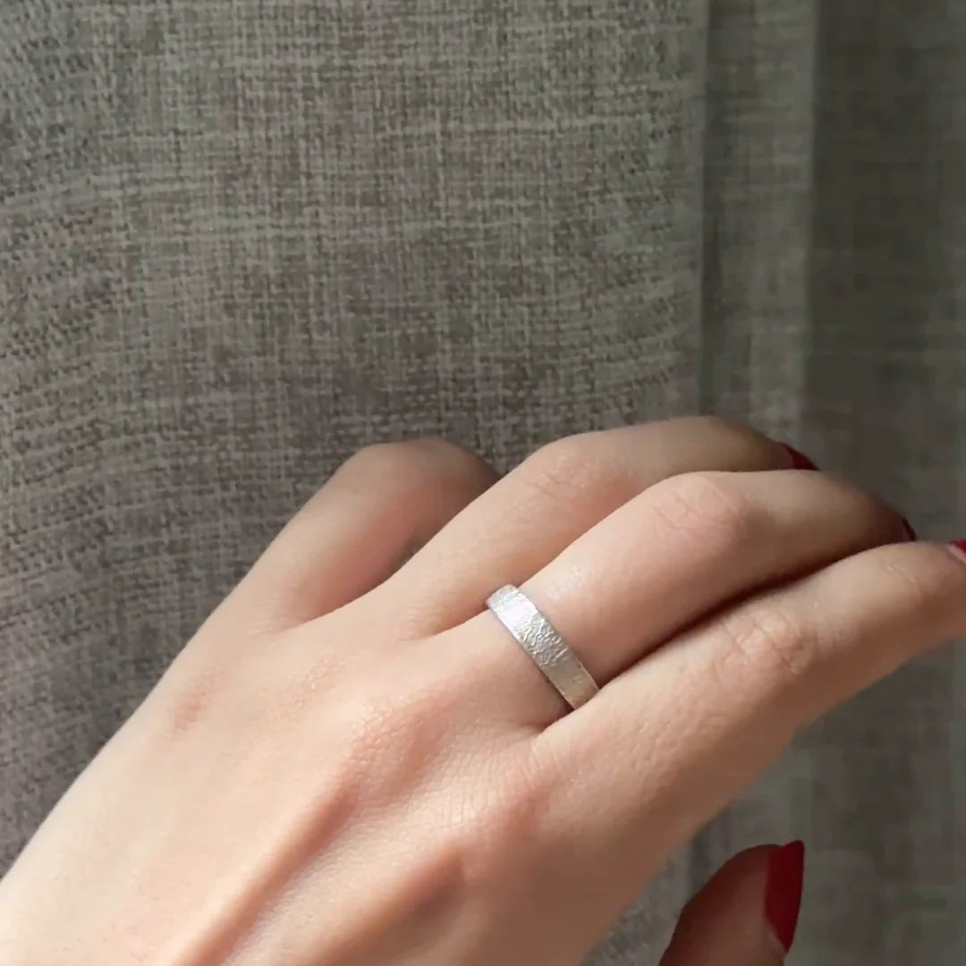 Anillo Huella Argolla de plata .925 puesto, de cerca, con la textura de la huella