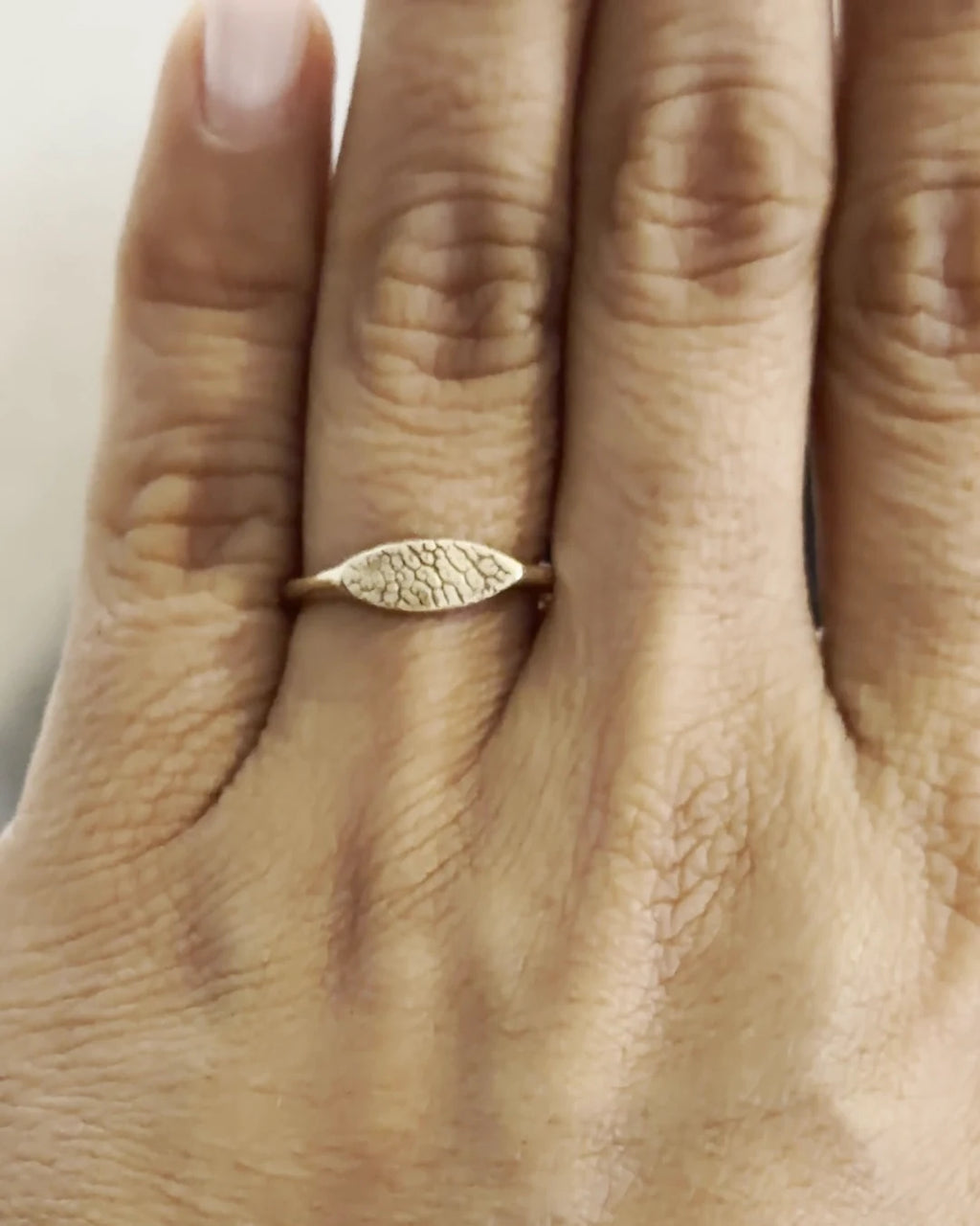 Anillo Huella Botánica en oro sólido puesto en la mano de una clienta