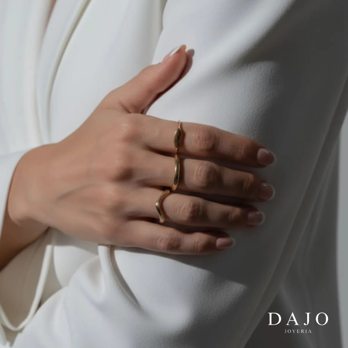 Modelo mujer usando combinación set de joyería anillos y cadenas Oro Vermeil plata .925 con baño de oro de 14K quilates estilo elegante con saco blazer traje. Anillo balance, argolla, botanica