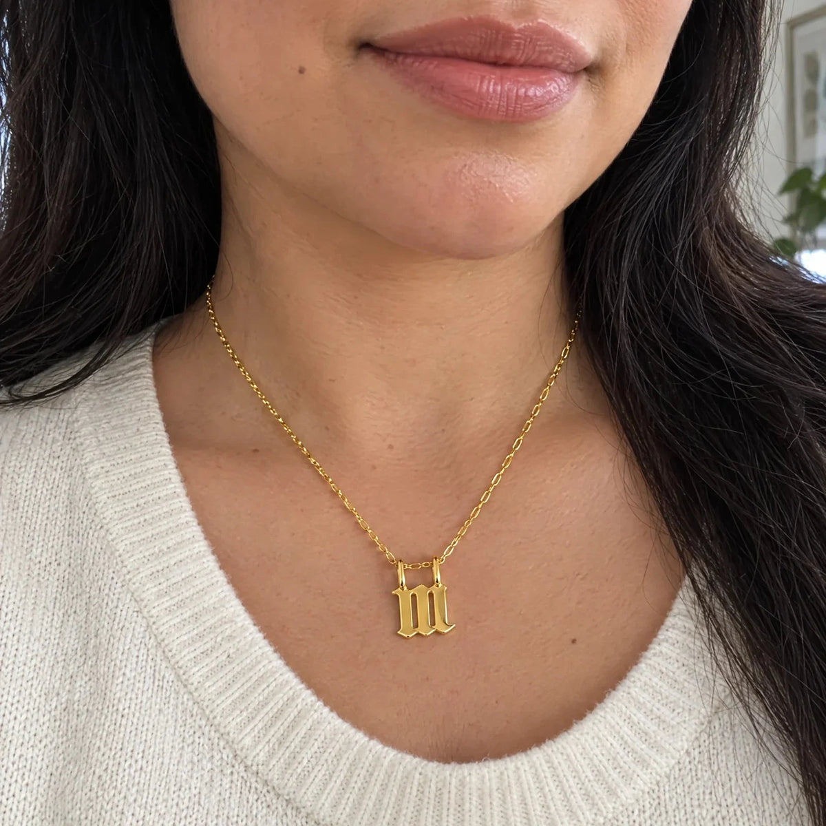 Dije Número Ángel 111 de oro sólido de DAJO puesto con suéter crema, a su tamaño real