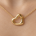 Detalle del Dije Corazón Irregular de oro sólido de DAJO, la cadena pasa por el hueco