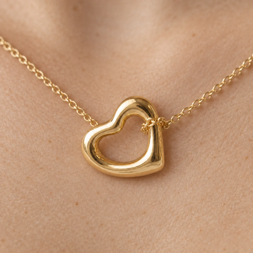 Detalle del Dije Corazón Irregular de oro sólido de DAJO, la cadena pasa por el hueco