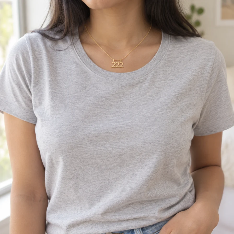Mujer con el Dije Número Ángel 222 de oro sólido de DAJO y playera gris