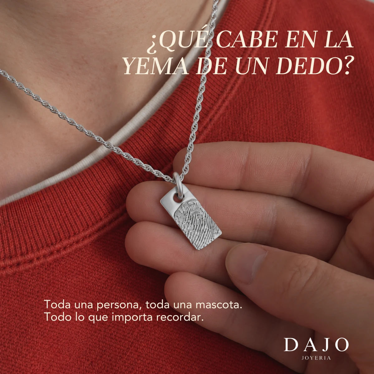 Dije Marco con huella de plata sostenido en la mano: qué cabe en la yema de un dedo