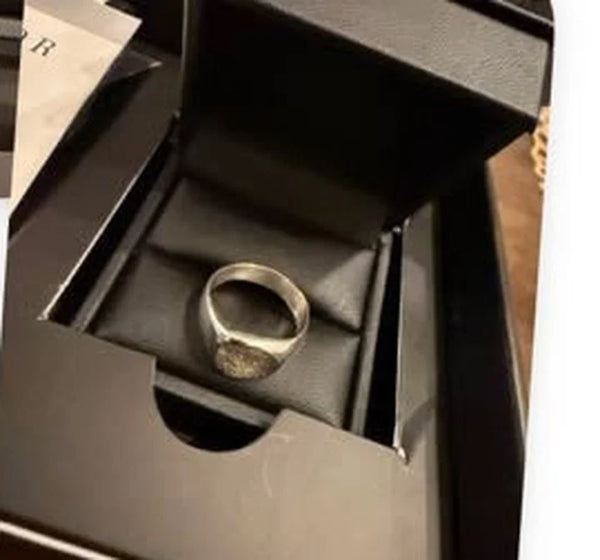 Anillo de plata con huella, dentro de su caja negra, recién llegado a casa