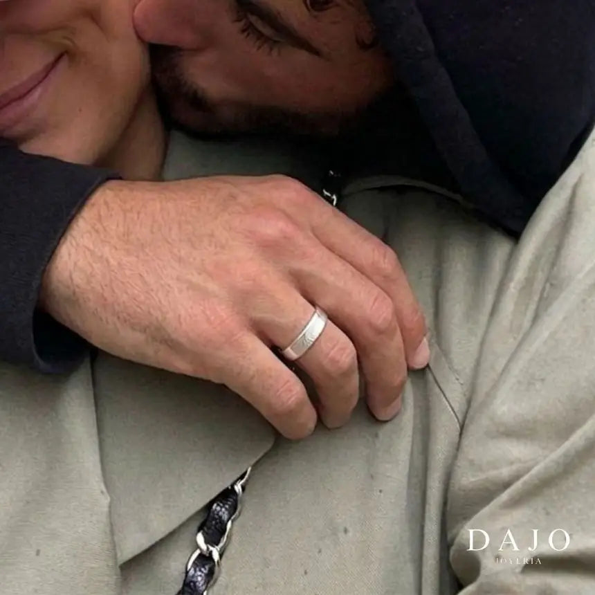 Pareja abrazada, con sus argollas de matrimonio de plata