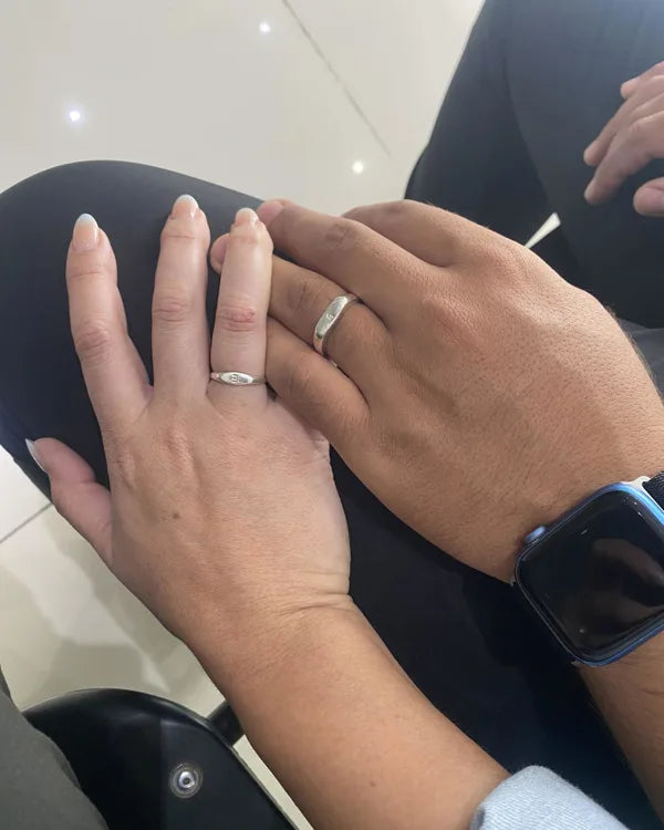Dos manos juntas, cada una con su anillo Botánica con inicial